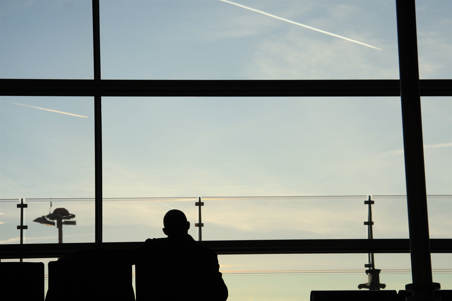 Mann på flyplass som sitter og ser ut vindu